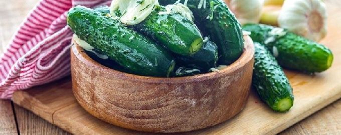 Concombres classiques croustillants légèrement salés dans une casserole avec eau froide, saumure